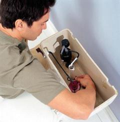 plumber adjusts bob valve in a toto toilet